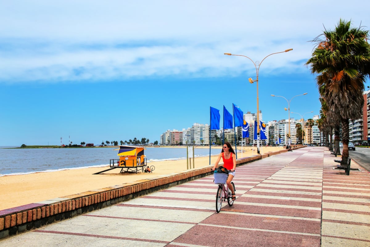 Woman riding bike along beach in Uruguay